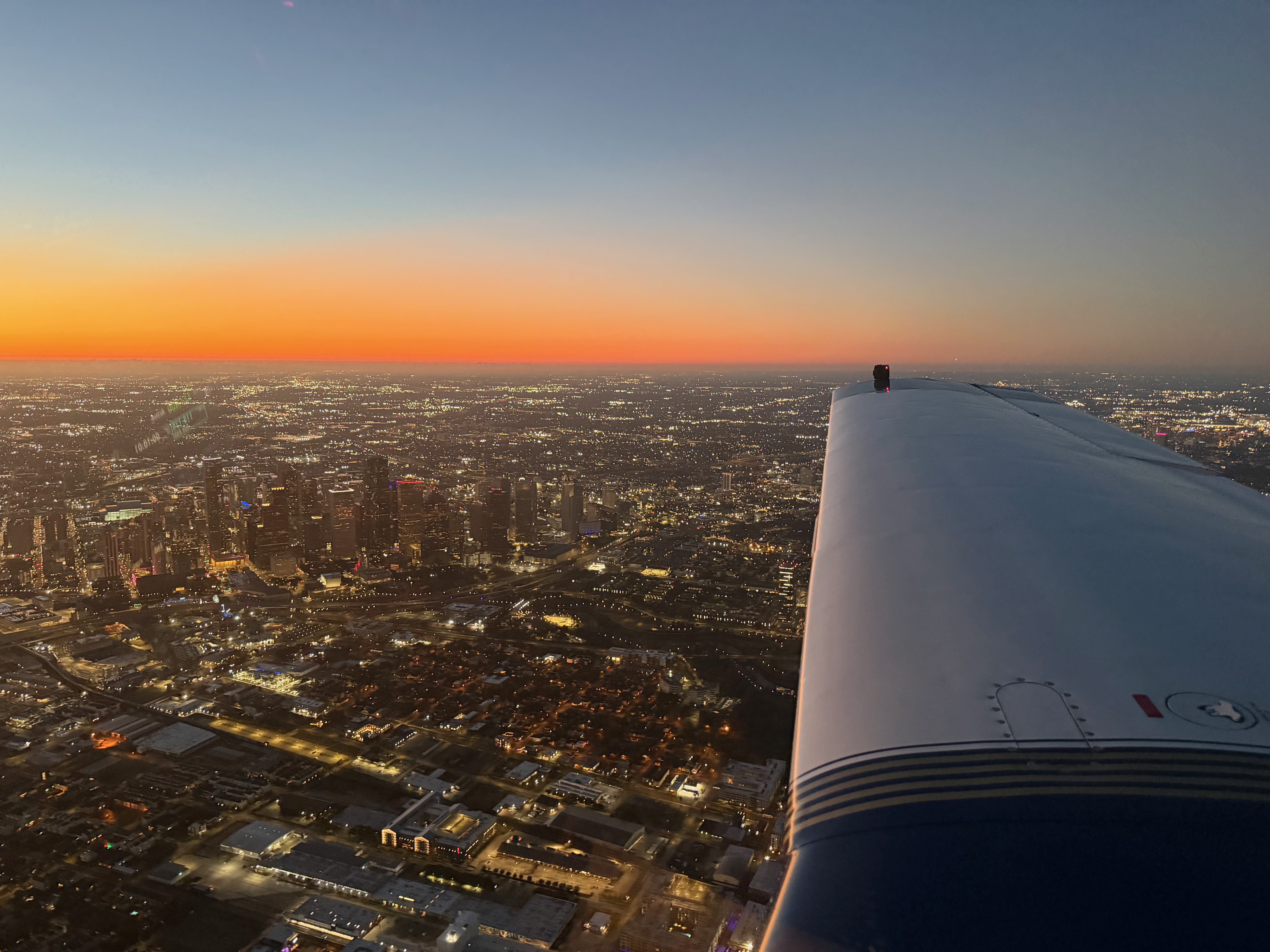 Aerial view at sunset from the cockpit — the horizon over Houston